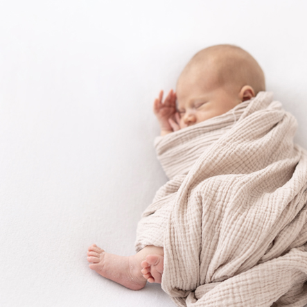 Slapende newborn baby in een swaddle